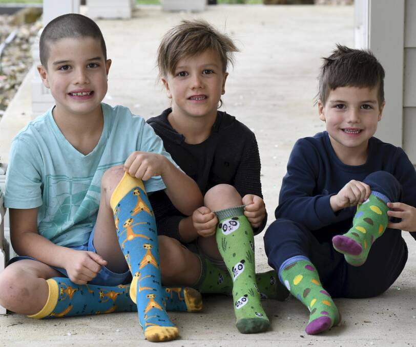 PULL THEM UP: Jhett, 8, Judd, 7, and Jordi Bower, 5, sport their Jolly Soles socks to help raise money for Keeley's Cause. Picture: Lachlan Bence