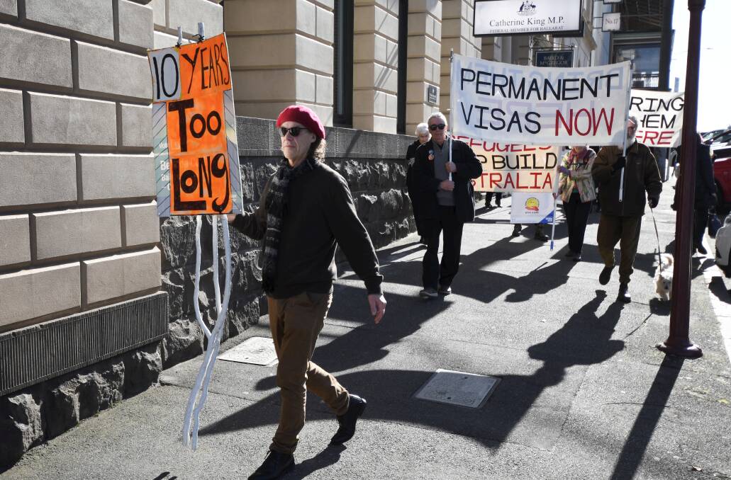 Refugee advocates march down Lydiard Street North. Picture by Lachlan Bence