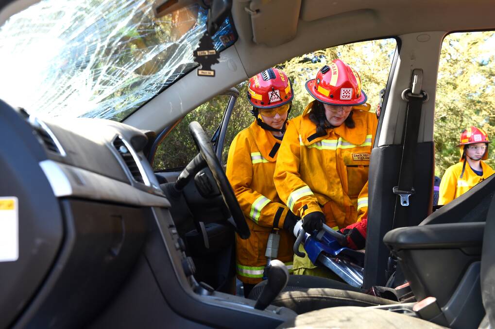 Teenagers Claire and Bridie learn how to get into a vehicle using the jaws of life during the Girls on Fire pilot program at Creswick. Picture by Adam Trafford.