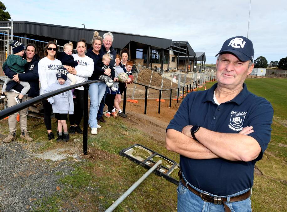 Ballan Football Netball Club treasurer Mark Conlan and other members stands outside the club's unfinished new facilities. Picture by Lachlan Bence