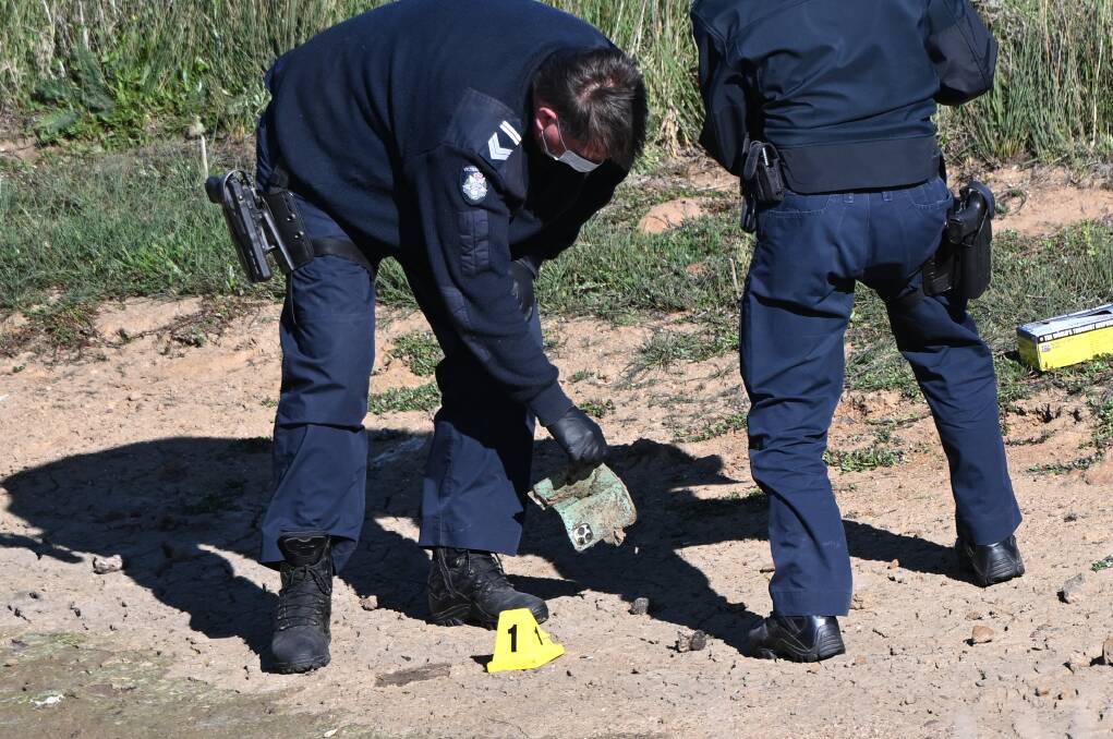 Police inspecting possible evidence on the banks of a dam, south of Ballarat. Picture by Lachlan Bence. 