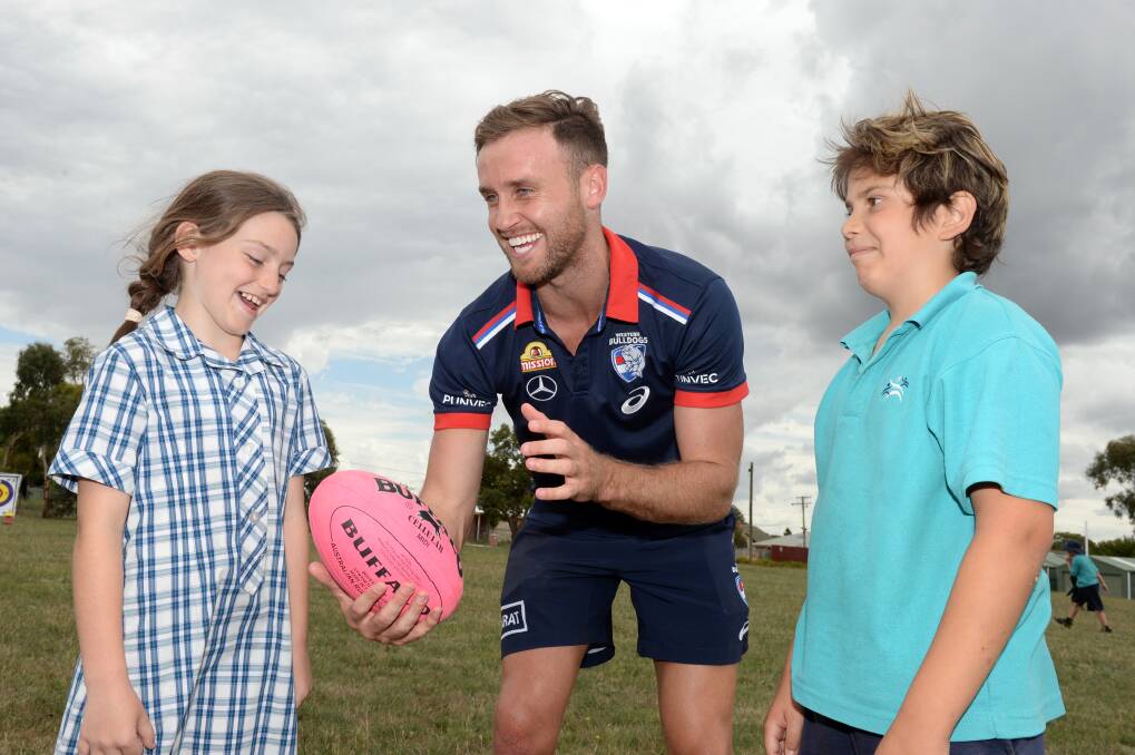 Western Bulldogs defender Hayden Crozier shares skills with Yuille Park pupils Ruby and Jacob in the club's last community camp in town, three years ago. Picture by Kate Healy