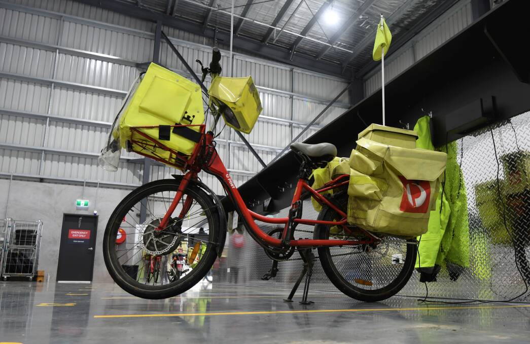 The well-known postie bike in a waiting bay while others are out on the road with deliveries. 