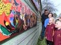 Artist Dale Oliver, Creswick choir member Willow, age 11 and Creswick's North Primary School's Olivia, grade one and Tyler, prep, admire the growing Indigenous-inspired mural in the Creswick Neighbourhood Centre garden, which opened on July 24, 2024. Picture by Kate Healy