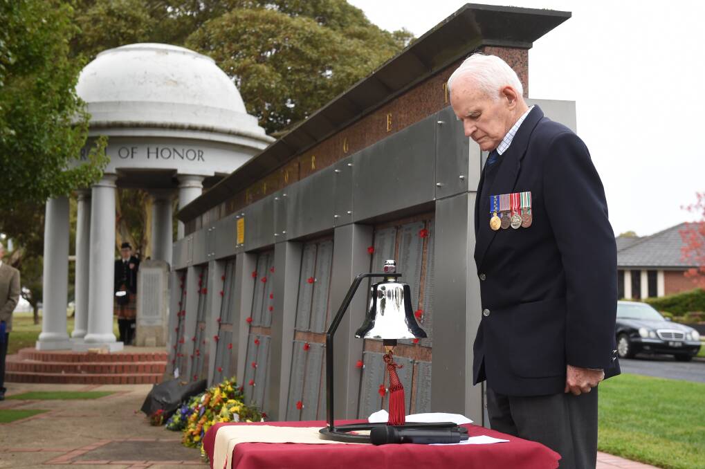 The Roll of Honour rotunda, featuring a piper, at the end of the Memorial Wall in a scene from the 2021 Anzac Day commemorative service. Picture by Kate Healy