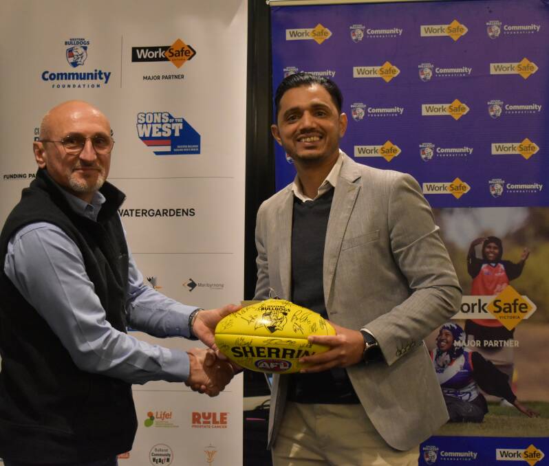 Petro Georgiou receives the 2022 Sons of the West Ballarat Club Champion award from Western Bulldogs Community Foundation general manager Kashif Bouns. Picture Western Bulldogs