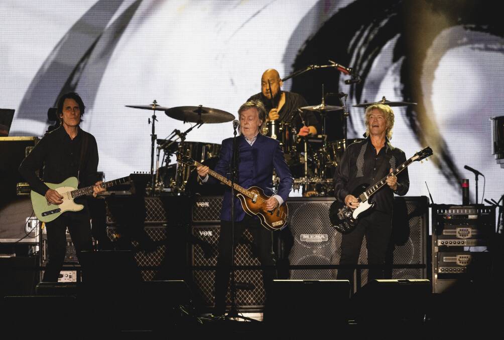 His band might be different, but Paul McCartney makes special tributes to Beatles John Lennon and George Harrison. Picture Newcastle Herald