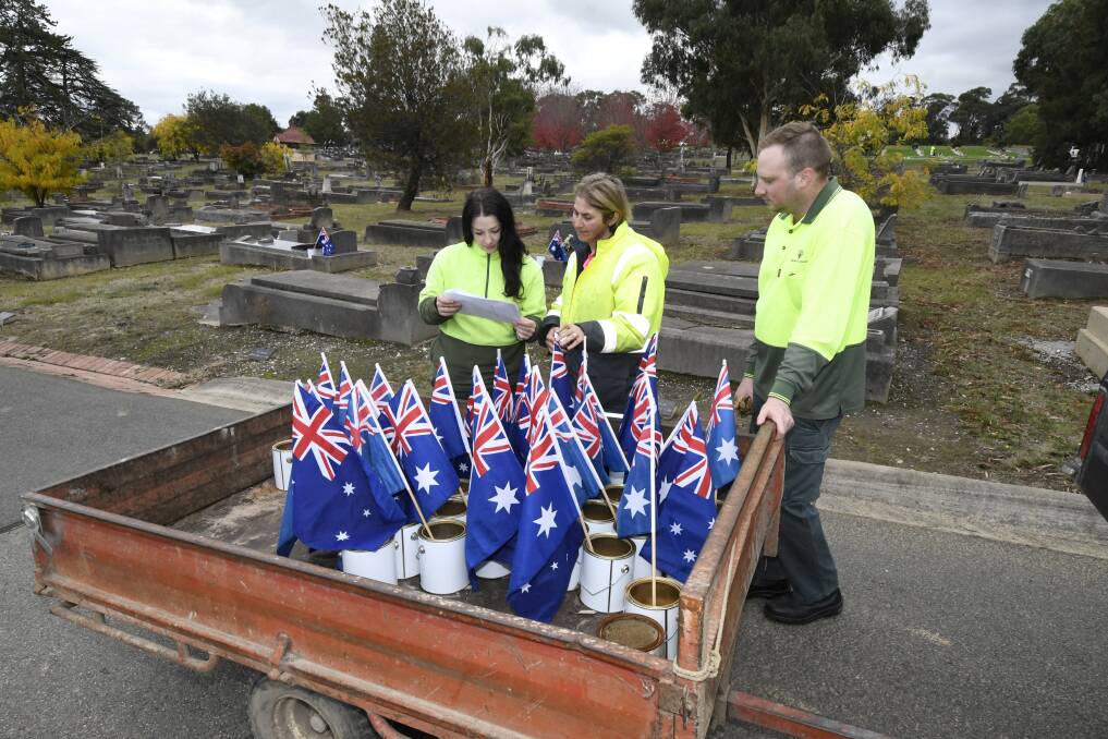 Alex Lee, Gayle Hunt, Will Oldaker prepare the distribution of Anzac Day for servicemen and women this week in Ballarat New Cemetery. Picture by Lachlan Bence