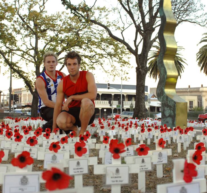East Point's Chris Banwell - now Skipton's coach - and Ballarat's Brad Anderson in the field of poppies in central Ballarat ahead of a traditional Anzac Day match in 2008. 