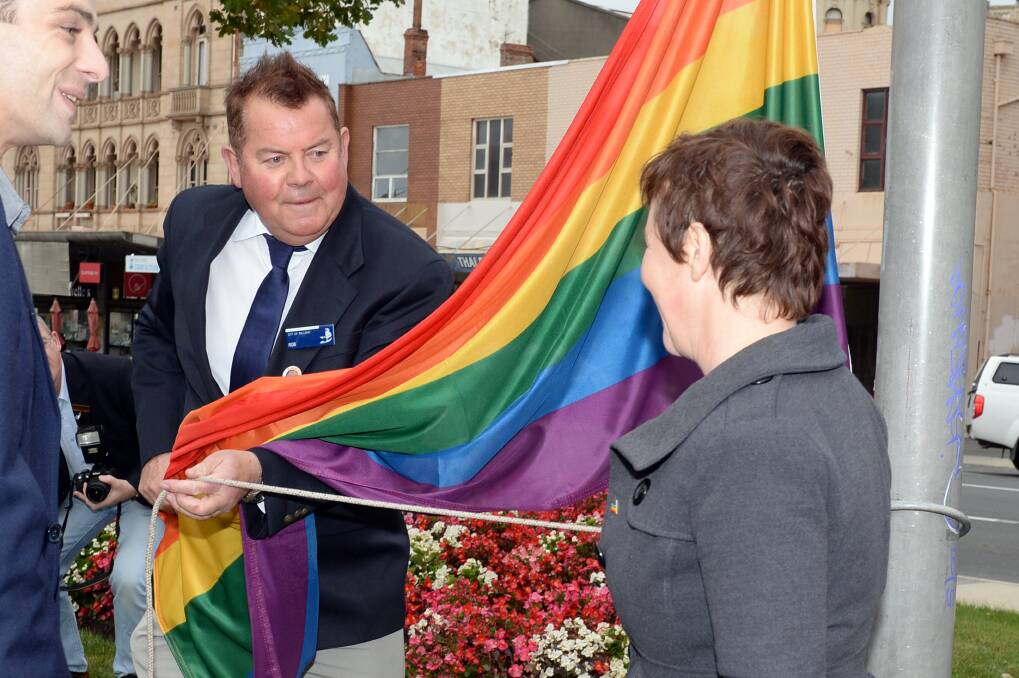 Rob McVitty helps City of Ballarat councillor Belinda Coates to raise the rainbow flag. Picture by Kate Healy