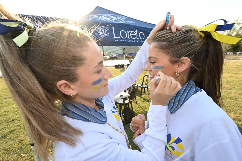 Facepaint is an important part of the spit crews, as Loreto's Abby Blee and Edie Folkei show. Picture by Lachlan Bence