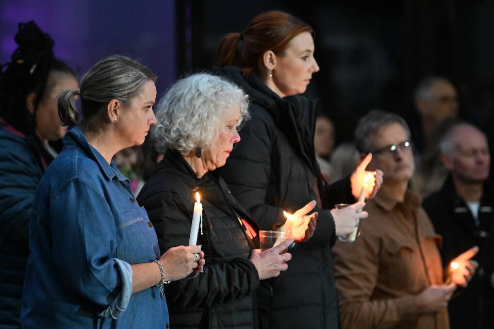 Candles are lit at Alfred Deakin Place. Picture by Lachlan Bence