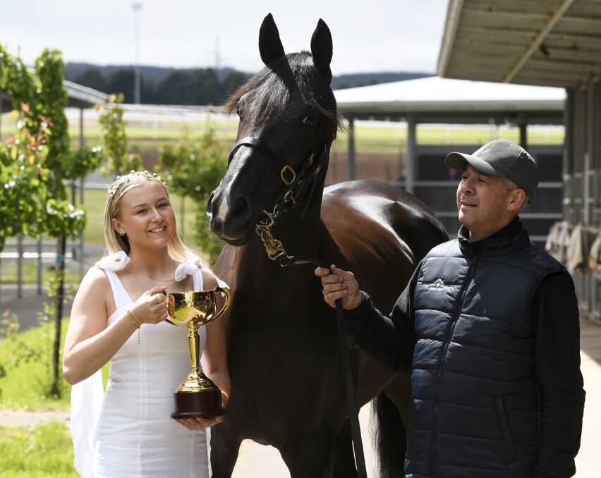 Emily Glass holds the Ballarat Cup with Andrew Noblet and his cup runner Foxy Frida. Picture by Lachlan Bence