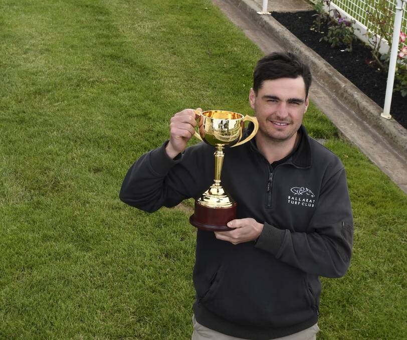 Ballarat racecourse manager Nick Stubbs, pictured with the Ballarat Cup trophy, has the track and surrounds in great shape for Saturday. Picture by Lachlan Bence.