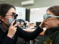 Optometrist Dr Yang Wang performs a vision test on Warrenheip Primary School year three student Lillian as part of the Glasses for Kids program. Picture by Lachlan Bence