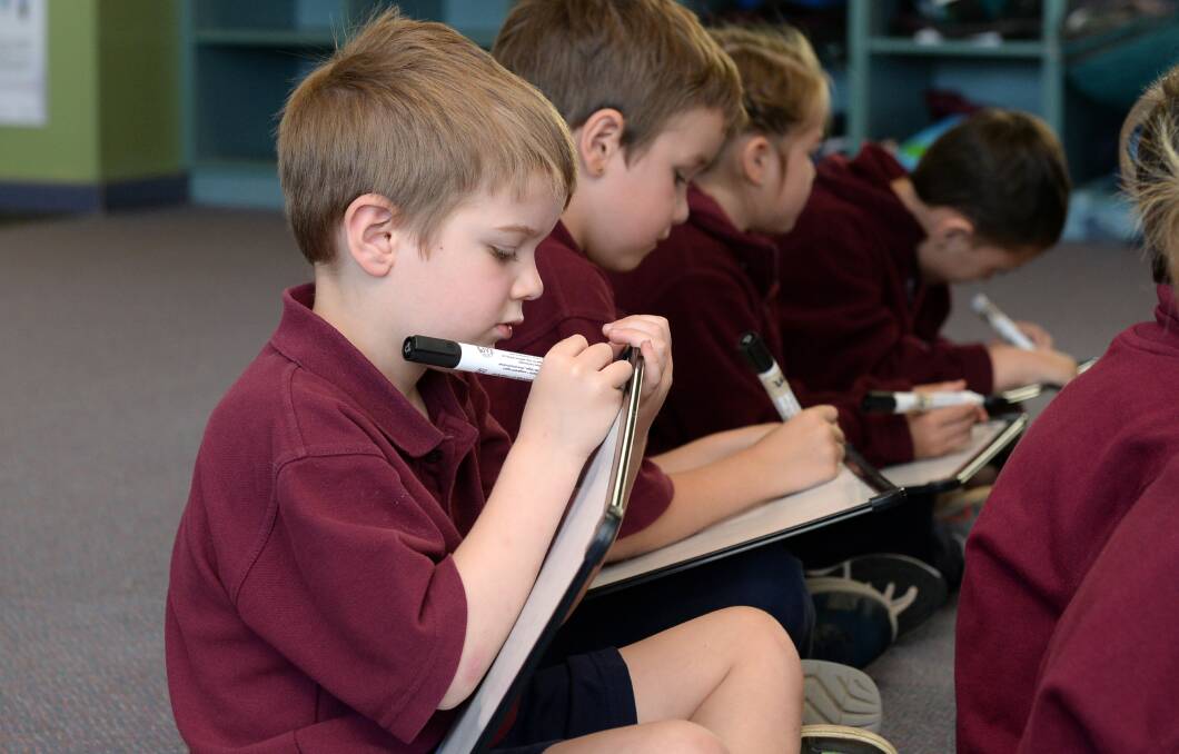 Junior primary school pupils at Mount Blowhard Primary School including John have been learning to read using phonics, including writing on whiteboards so teachers can immediately see if children understand the lesson. File picture 