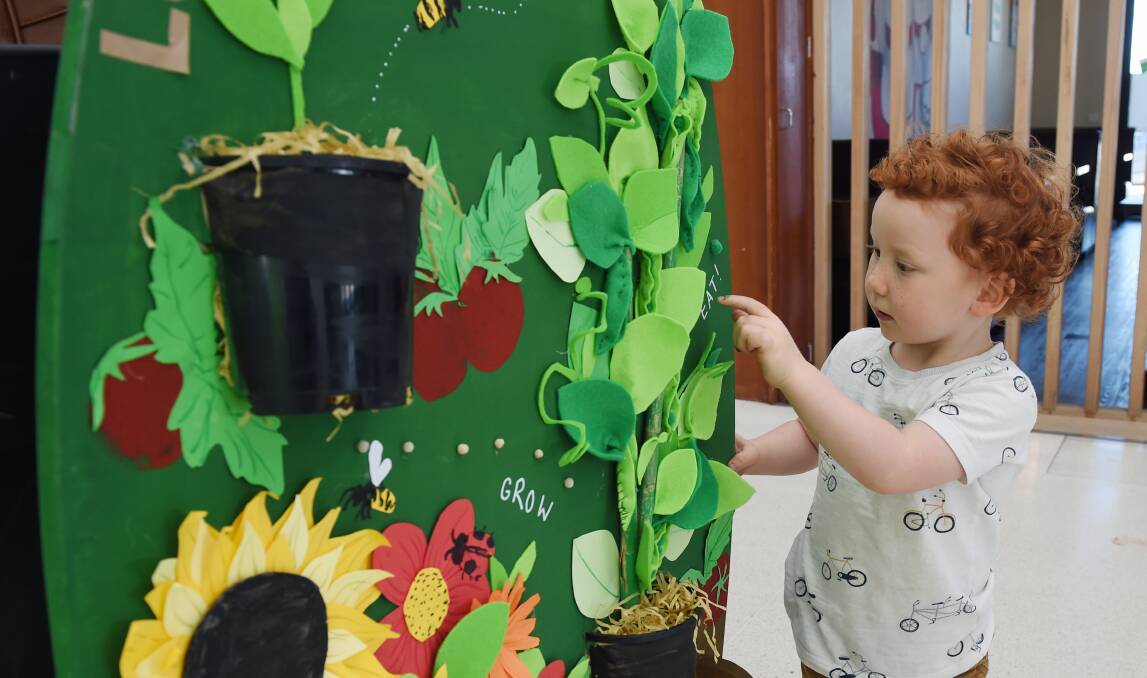 GREEN: Micah Scott, 2, with the Lucas Community Garden decorated egg. Photo: Kate Healy