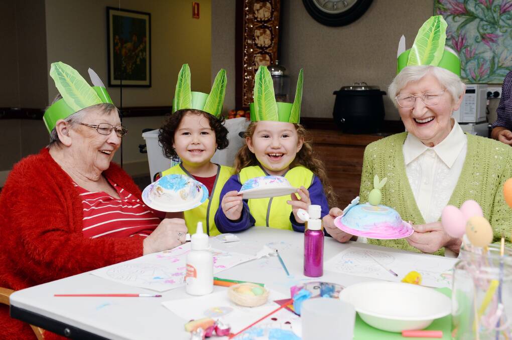 Weekly visits between childcare and aged care have grown new relationships. Journey Delacombe childcare kids Rory and Zahra, 4, enjoyed Easter crafts earlier this year with Coral Lester and Alison James from BUPA Delacombe aged care. Picture by Kate Healy