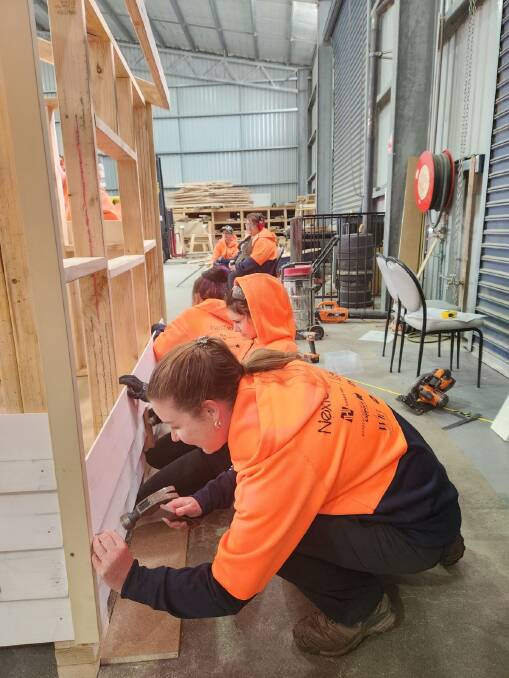 Polly Britten from Highlands LLEN wields the tools alongside girls building a cubby house as part of a NextGen Tradies - Try a Trade workshop. Picture supplied
