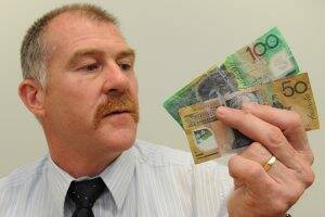 Fake: Detective Senior Constable Barry Hills with some dud notes.