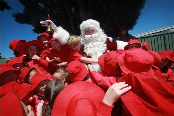 WELCOMED VISITOR: Santa is mobbed by pupils from Ballarat North Primary School. Picture:  Andrew Kelly